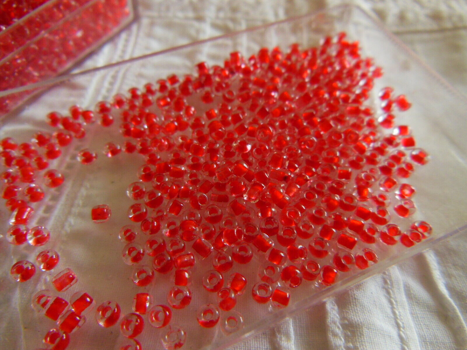 Lot environ 22 grammes de perles rocaille deux tons rouge et transparente  n°102