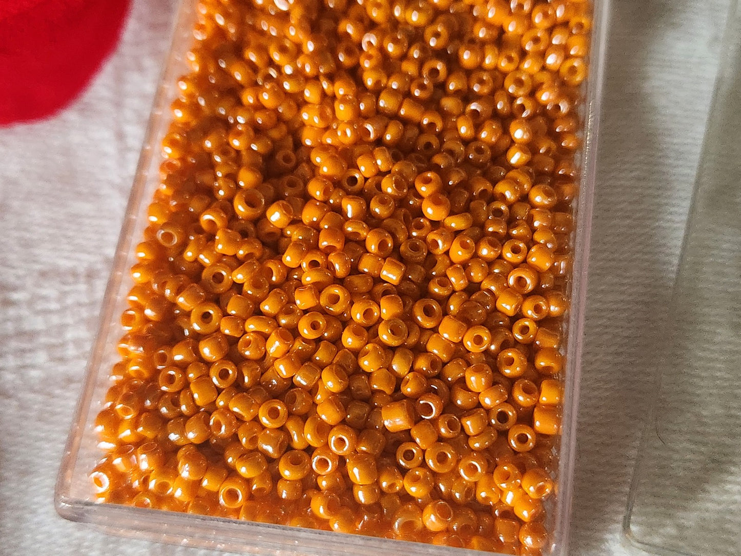 Lot environ 18  grammes de perles rocaille orange satiné n°13
