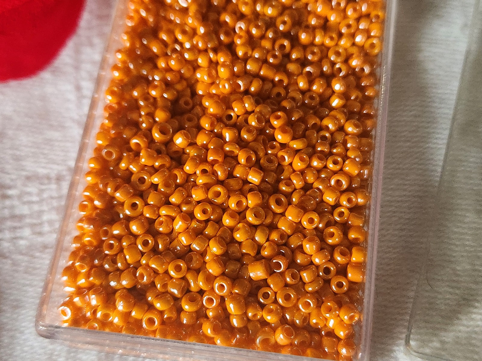 Lot environ 18  grammes de perles rocaille orange satiné n°13