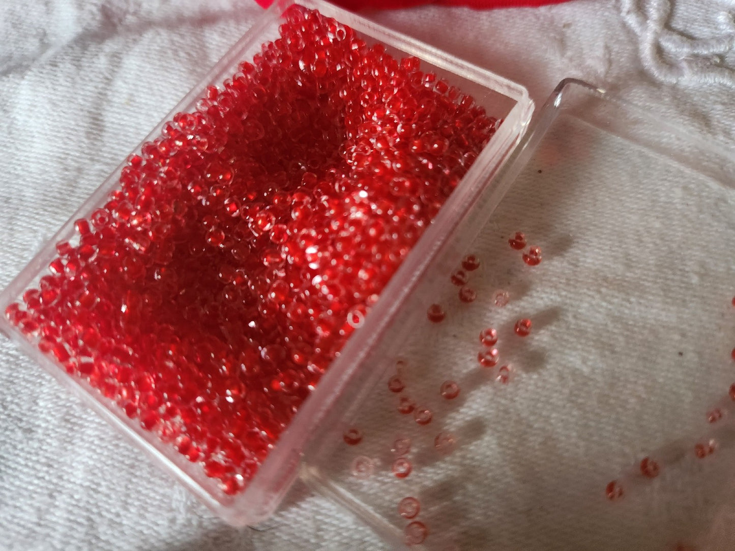 Lot environ 22 grammes de perles rocaille deux tons rouge et transparente  n°26