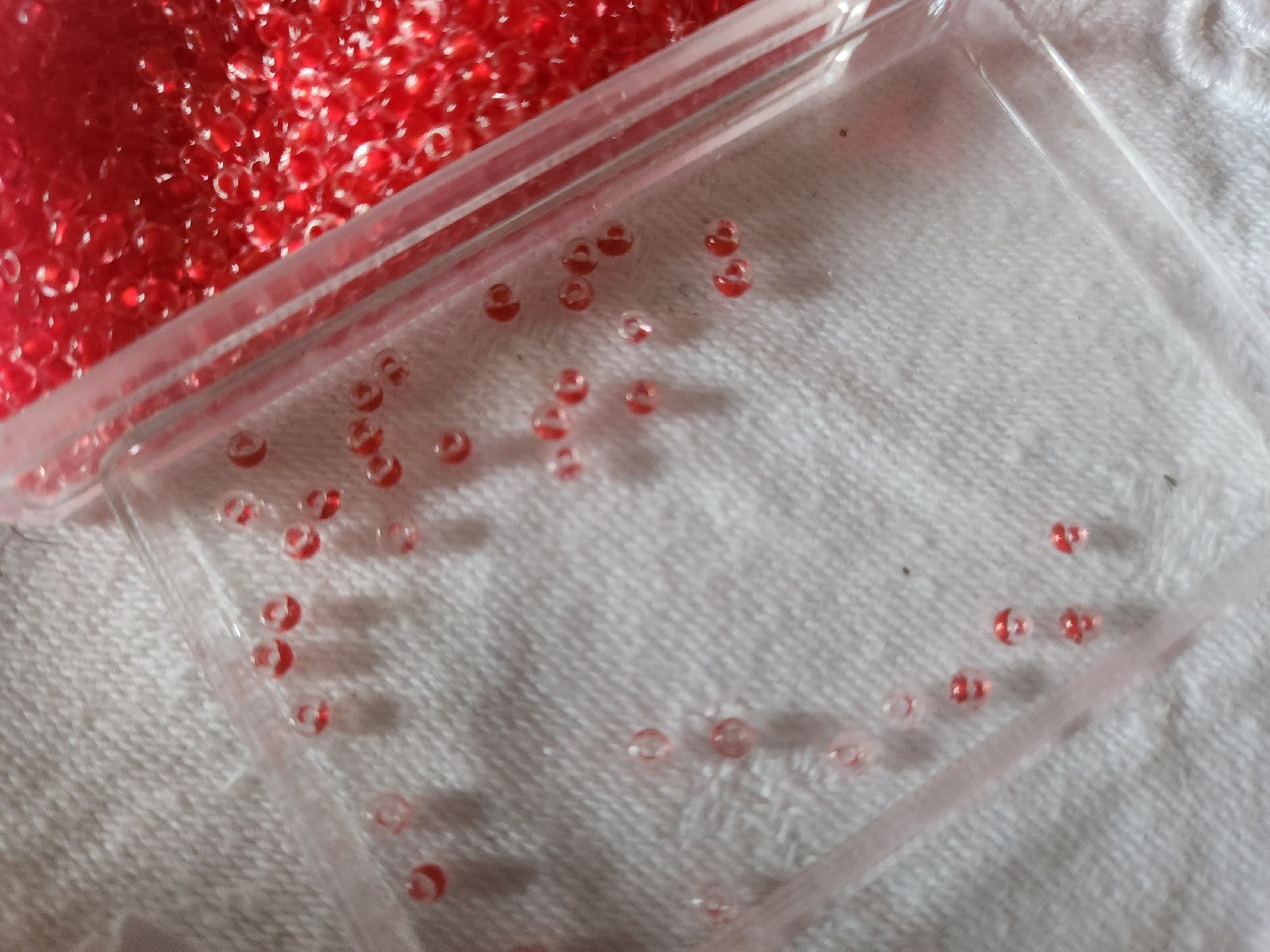 Lot environ 22 grammes de perles rocaille deux tons rouge et transparente  n°26