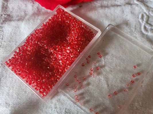 Lot environ 22 grammes de perles rocaille deux tons rouge et transparente  n°26