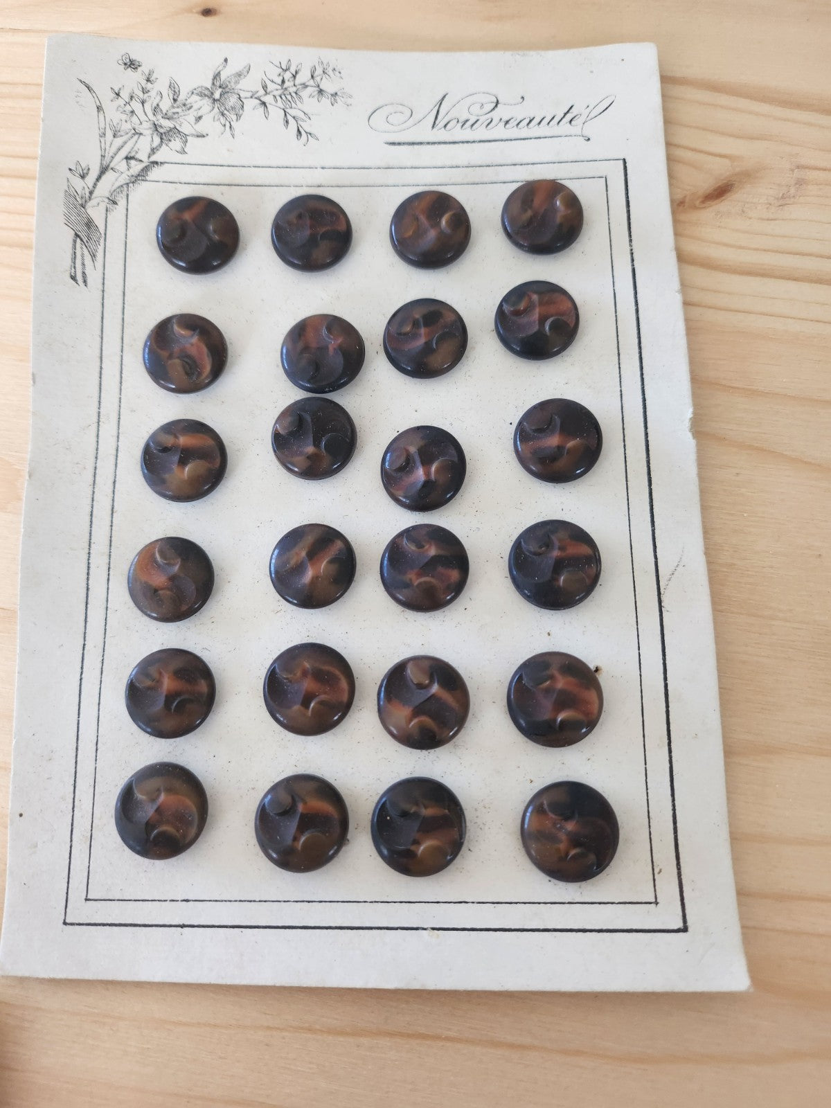 Plaque de 24 boutons anciens en corozo travaillé pied 1,4 cm
